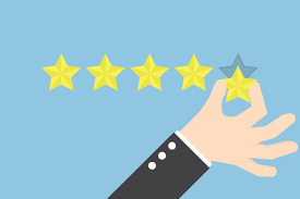image with light blue background and yellow rating stars in a horizontal line, four already placed and a fifth star being placed by a hand.