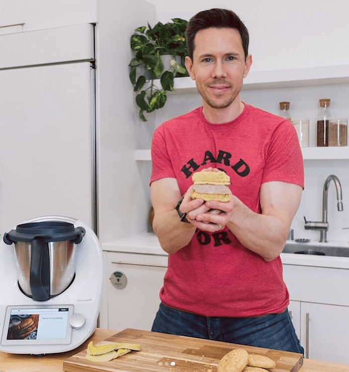 A photo of Bobby Parish holding a sandwich that likely has no bread or mayonnaise with vegetable oil in it.