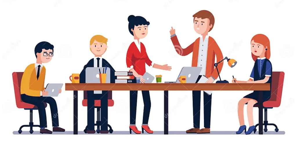 This is a picture of people in an office setting, sitting at a conference table. There are 2 people actively talking, one who is a white man and another who is an Asian woman.