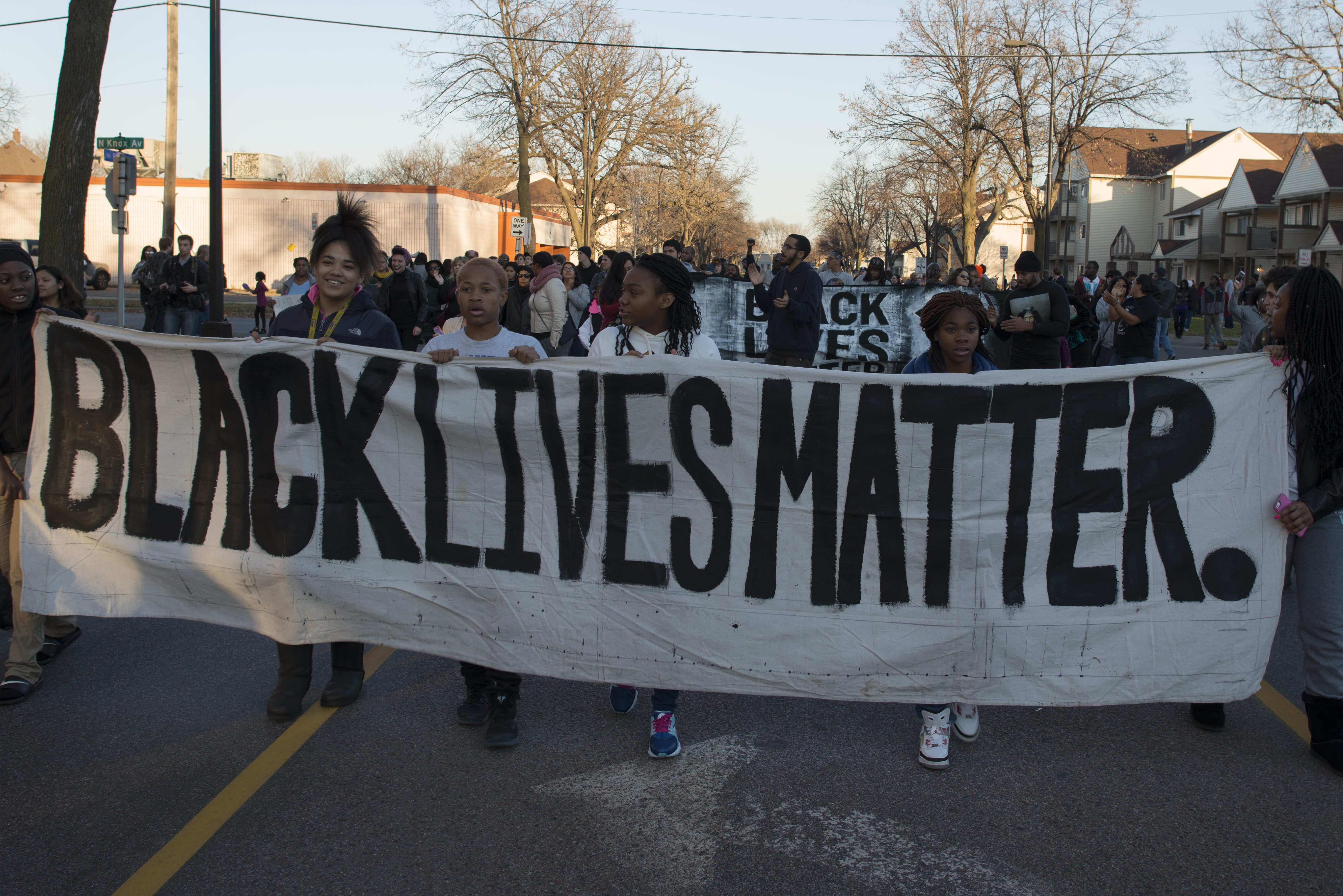 Young children hold a black lives matter banner at a march